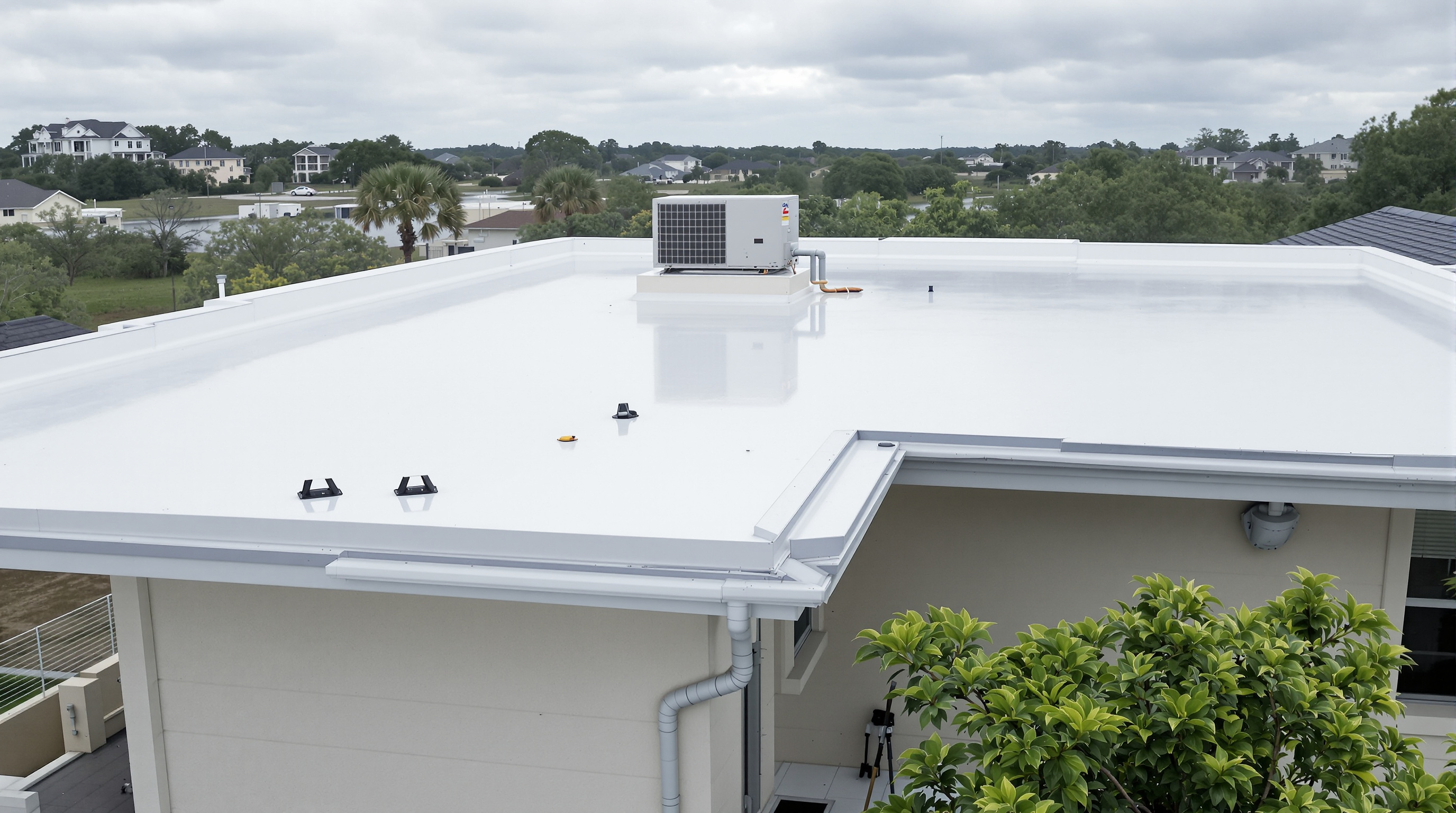 Black 60-mil EPDM synthetic rubber membrane being fully adhered to the substrate on a residential low-slope roof in South Alabama with the flat roofing contractor smoothing the material across tapered insulation board, a proven flat roofing system for Gulf Coast homes in Baldwin County where proper drainage design prevents ponding water accumulation that accelerates membrane degradation during the region wet season with 4 to 6 inch per hour rainfall intensity