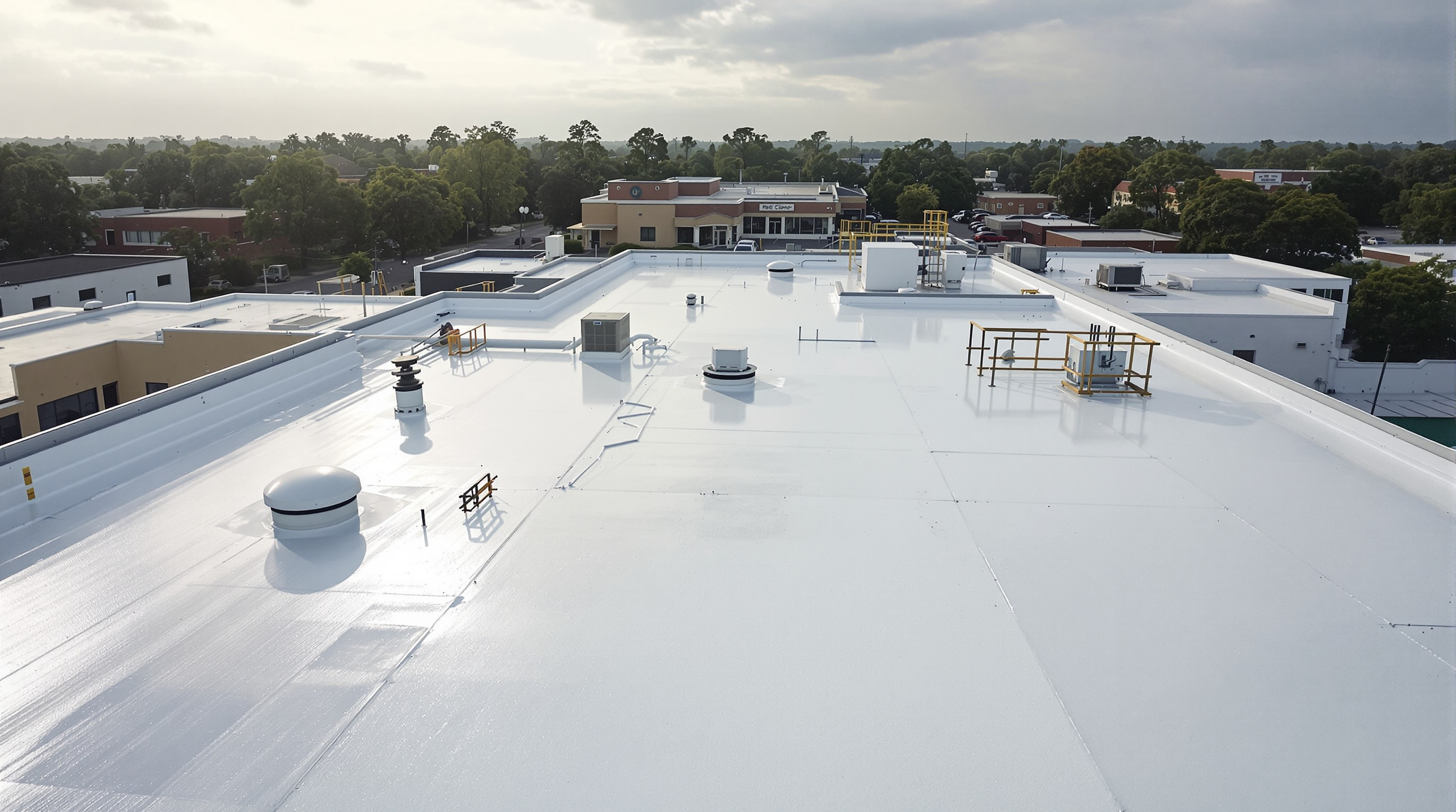 Aerial view of a white reflective TPO commercial roofing system on a low-slope building in South Alabama, demonstrating the 80 percent solar reflectivity that qualifies for ENERGY STAR Cool Roof designation and reduces annual cooling expenses by 10 to 20 percent compared to dark membrane systems on Gulf Coast commercial properties in Mobile and Baldwin County
